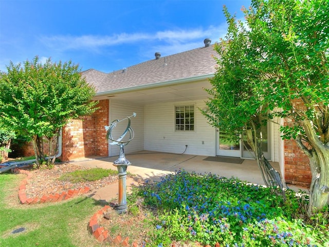 1204 Scrambler Ln, Edmond, OK 73025 - back of house with a patio, a shingled roof, and brick siding