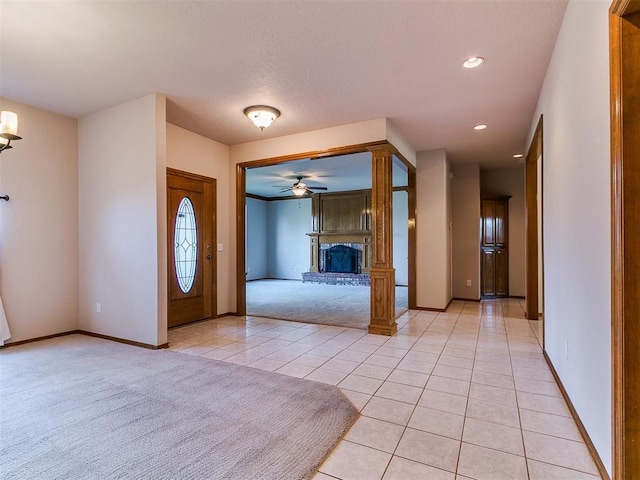 1204 Scrambler Ln, Edmond, OK 73025 - foyer with light tile patterned floors, a fireplace with raised hearth, ceiling fan, recessed lighting, and light colored carpet