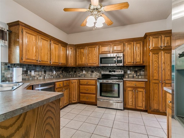 1204 Scrambler Ln, Edmond, OK 73025 - kitchen with appliances with stainless steel finishes, brown cabinets, decorative backsplash, and light tile patterned floors