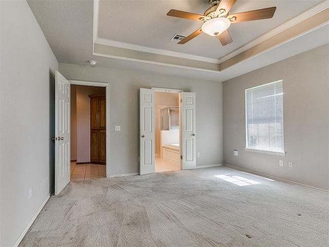 1204 Scrambler Ln, Edmond, OK 73025 - unfurnished bedroom with a raised ceiling, carpet floors, crown molding, connected bathroom, and ceiling fan