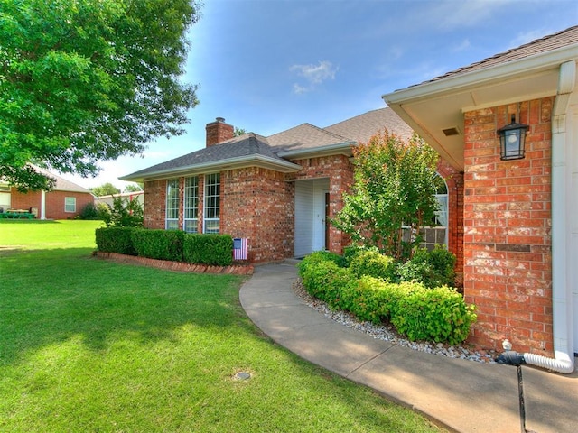 1204 Scrambler Ln, Edmond, OK 73025 - view of front of house featuring brick siding, a chimney, and a front yard