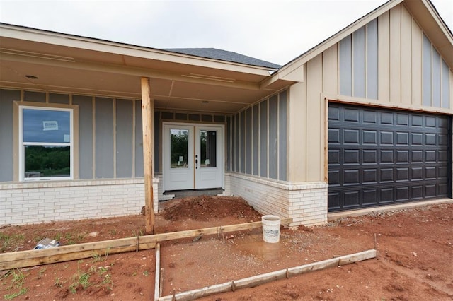 41364 Hazel Dell Rd, Shawnee, OK 74804 - doorway to property with board and batten siding, brick siding, a garage, and french doors