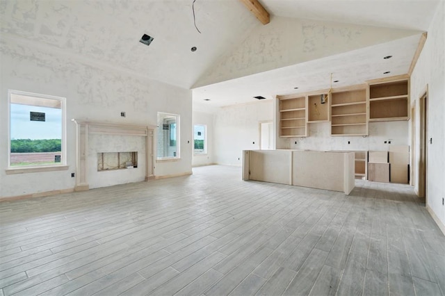 41364 Hazel Dell Rd, Shawnee, OK 74804 - unfurnished living room with high vaulted ceiling, beamed ceiling, light wood finished floors, and a premium fireplace