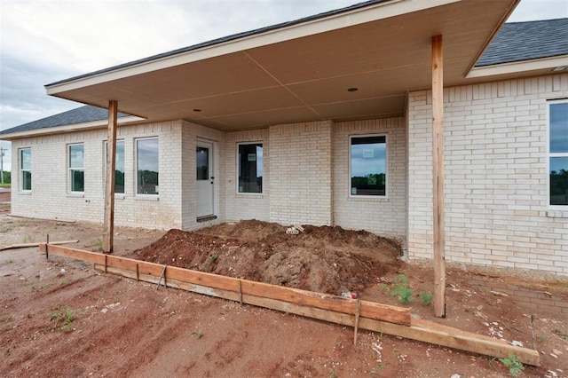 41364 Hazel Dell Rd, Shawnee, OK 74804 - view of exterior entry featuring brick siding and a shingled roof