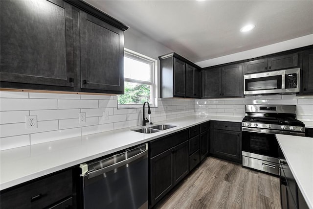 1417 Mallard Dr, Del City, OK 73115 - kitchen featuring appliances with stainless steel finishes, wood finished floors, decorative backsplash, light countertops, and recessed lighting