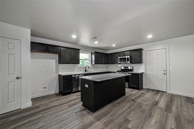 1417 Mallard Dr, Del City, OK 73115 - kitchen featuring stainless steel appliances, dark wood-style flooring, a kitchen island, tasteful backsplash, and recessed lighting
