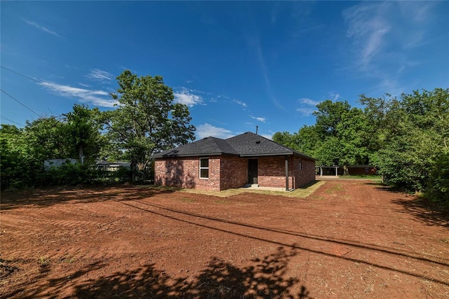 1417 Mallard Dr, Del City, OK 73115 - rear view of house with brick siding, driveway, and roof with shingles