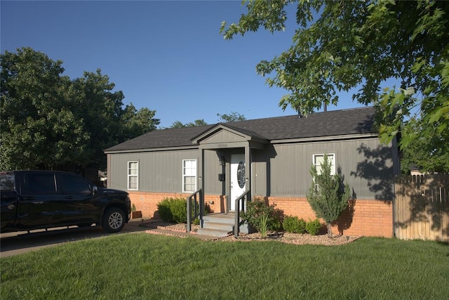 9008 N Walker Ave, Oklahoma City, OK 73103 - view of front of house with brick siding, a front yard, and a shingled roof