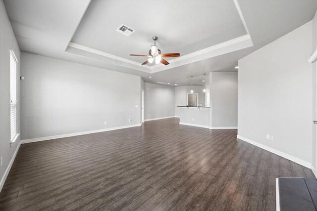 641 Geneva Dr, Edmond, OK 73025 - unfurnished living room featuring a tray ceiling, ceiling fan, dark wood finished floors, healthy amount of natural light, and recessed lighting