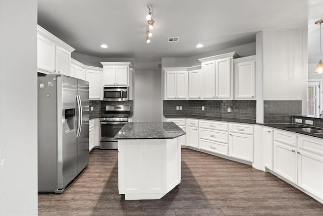 641 Geneva Dr, Edmond, OK 73025 - kitchen featuring appliances with stainless steel finishes, white cabinetry, tasteful backsplash, recessed lighting, and a center island