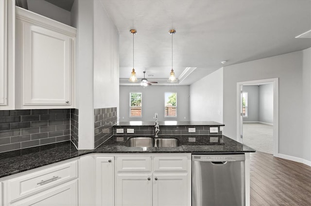 641 Geneva Dr, Edmond, OK 73025 - kitchen featuring stainless steel dishwasher, a peninsula, wood finished floors, white cabinets, and dark stone countertops