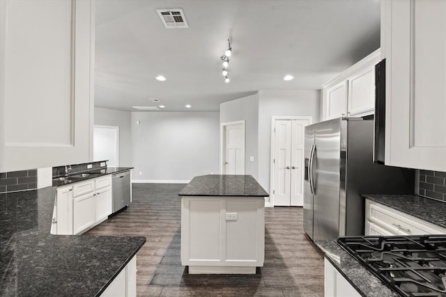 641 Geneva Dr, Edmond, OK 73025 - kitchen with stainless steel appliances, a kitchen island, dark wood-style flooring, white cabinets, and recessed lighting