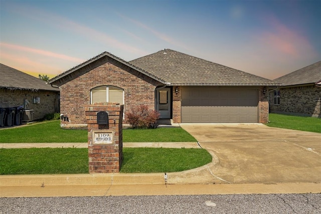 1109 Hickory Creek Dr, Yukon, OK 73099 - ranch-style house with concrete driveway, a garage, brick siding, and a front lawn