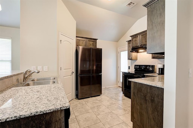 1109 Hickory Creek Dr, Yukon, OK 73099 - kitchen with freestanding refrigerator, black electric range oven, under cabinet range hood, lofted ceiling, and dark brown cabinets