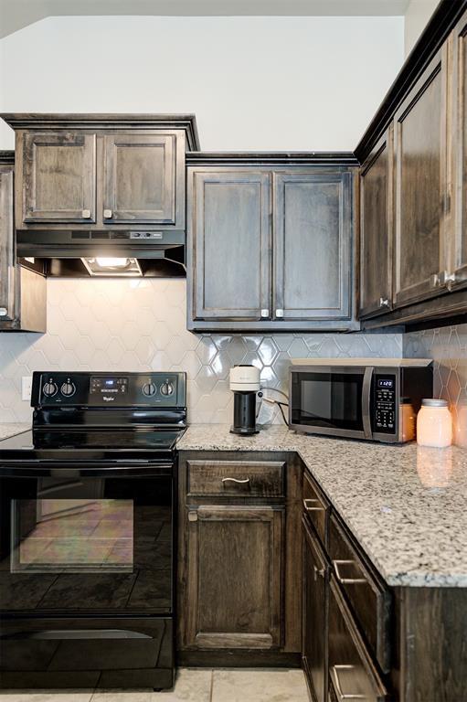 1109 Hickory Creek Dr, Yukon, OK 73099 - kitchen featuring black / electric stove, stainless steel microwave, under cabinet range hood, and dark brown cabinets