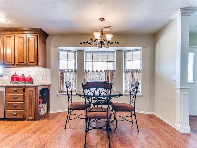 2349 Fox Ln, Blanchard, OK 73010 - dining room with light wood-type flooring, a chandelier, plenty of natural light, and a textured ceiling