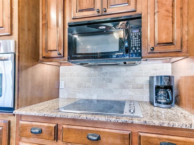 2349 Fox Ln, Blanchard, OK 73010 - kitchen featuring black appliances, brown cabinetry, backsplash, and light stone countertops