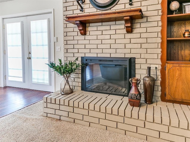 2349 Fox Ln, Blanchard, OK 73010 - detailed view of a brick fireplace, french doors, and wood finished floors