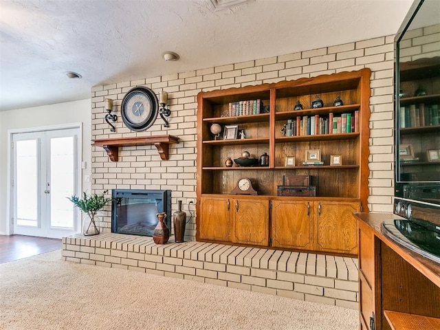 2349 Fox Ln, Blanchard, OK 73010 - living area with a textured ceiling, french doors, and a brick fireplace