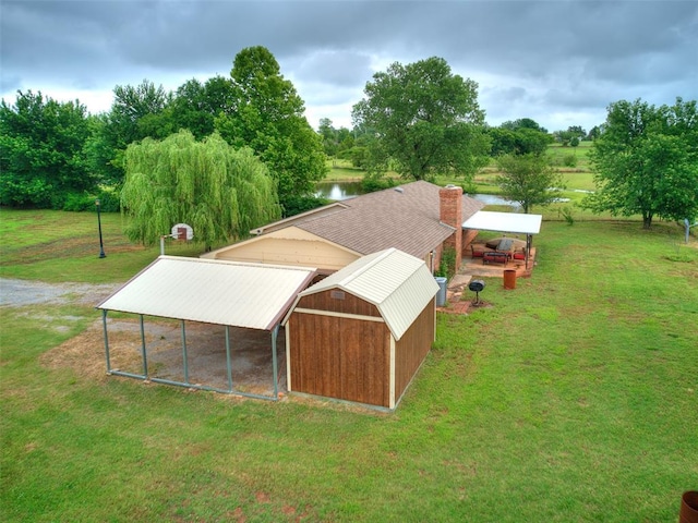 2349 Fox Ln, Blanchard, OK 73010 - view of property exterior with a yard, a pole building, an outdoor structure, a water view, and a chimney