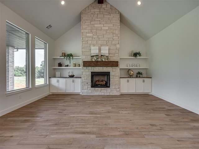 7625 Leoma Ln, Oklahoma City, OK 73150 - unfurnished living room featuring high vaulted ceiling, a stone fireplace, light wood-style floors, and recessed lighting