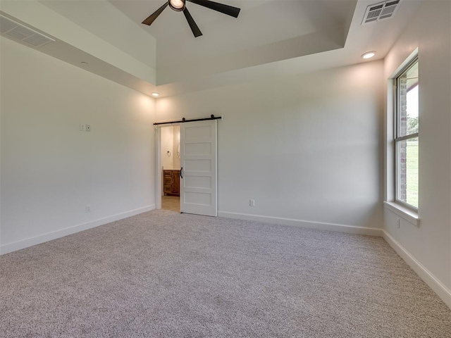 7625 Leoma Ln, Oklahoma City, OK 73150 - unfurnished room featuring a barn door, light carpet, a ceiling fan, a raised ceiling, and recessed lighting