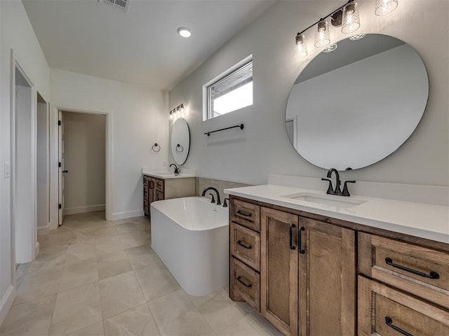 7625 Leoma Ln, Oklahoma City, OK 73150 - bathroom featuring two vanities, a freestanding tub, and tile patterned flooring