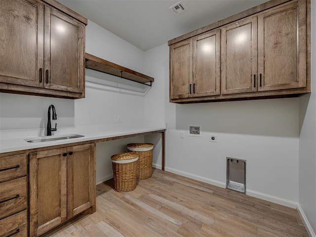 7625 Leoma Ln, Oklahoma City, OK 73150 - washroom with cabinet space, hookup for a washing machine, light wood-style flooring, and hookup for an electric dryer