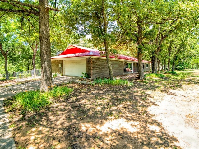 114 Timber Ln, Mcloud, OK 74851 - view of property exterior featuring brick siding, a garage, and driveway