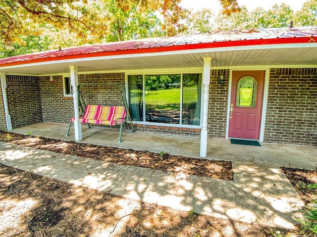 114 Timber Ln, Mcloud, OK 74851 - doorway to property featuring brick siding and covered porch