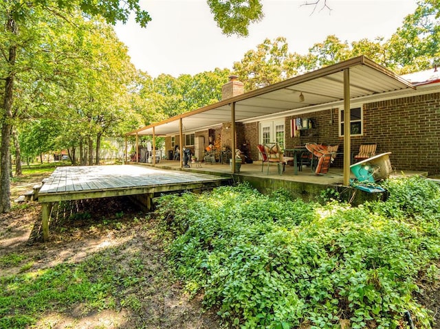 114 Timber Ln, Mcloud, OK 74851 - back of property featuring brick siding, a chimney, and a wooden deck