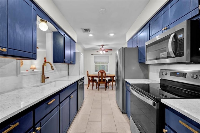 12414 SW 15th Ter, Yukon, OK 73099 - kitchen with appliances with stainless steel finishes, ceiling fan, backsplash, blue cabinetry, and recessed lighting