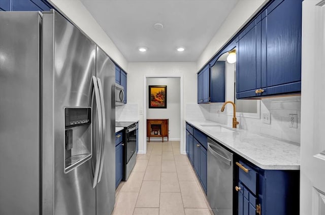 12414 SW 15th Ter, Yukon, OK 73099 - kitchen with stainless steel appliances, blue cabinets, light tile patterned floors, decorative backsplash, and recessed lighting