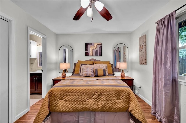 12414 SW 15th Ter, Yukon, OK 73099 - bedroom with wood finished floors, ensuite bathroom, and a ceiling fan