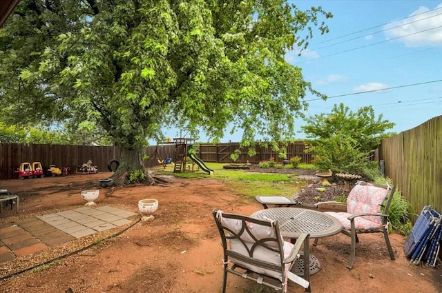 12414 SW 15th Ter, Yukon, OK 73099 - fenced backyard featuring a playground and a patio area