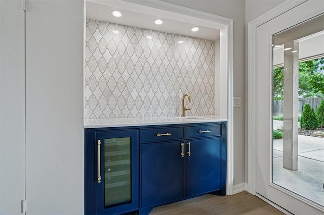 11209 Thorn Ridge Rd, Oklahoma City, OK 73120 - indoor wet bar featuring beverage cooler, decorative backsplash, recessed lighting, and wood finished floors