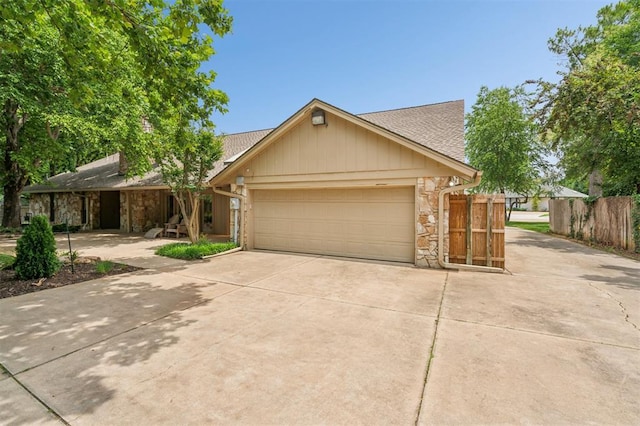11209 Thorn Ridge Rd, Oklahoma City, OK 73120 - view of front of home with driveway, stone siding, a garage, and roof with shingles
