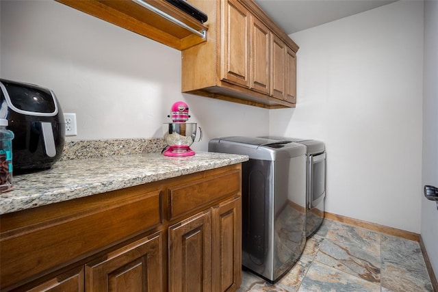 6813 Chelsey Ln, Oklahoma City, OK 73132 - laundry room featuring cabinet space, washer and clothes dryer, and stone tile floors