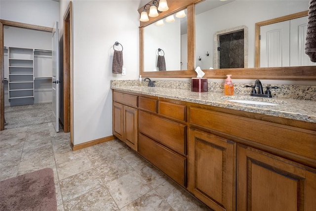 6813 Chelsey Ln, Oklahoma City, OK 73132 - bathroom with double vanity, stone finish floors, and a spacious closet