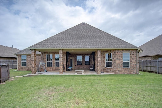 6813 Chelsey Ln, Oklahoma City, OK 73132 - rear view of property featuring roof with shingles, a fenced backyard, brick siding, and a patio