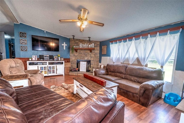 910903 S 3444th Rd, Chandler, OK 74834 - living area featuring a textured ceiling, wood finished floors, ceiling fan, a fireplace, and vaulted ceiling
