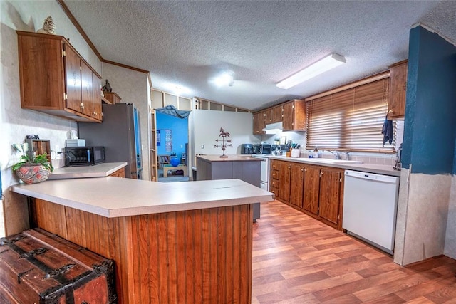 910903 S 3444th Rd, Chandler, OK 74834 - kitchen with white appliances, light wood-style flooring, a peninsula, brown cabinets, and a textured ceiling