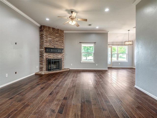 3922 Deer Xing, Edmond, OK 73025 - unfurnished living room with ceiling fan, dark wood-type flooring, ornamental molding, a brick fireplace, and recessed lighting