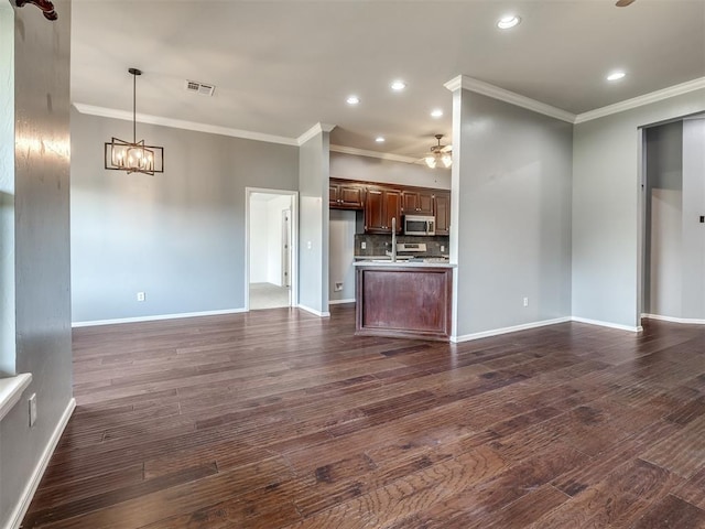 3922 Deer Xing, Edmond, OK 73025 - unfurnished living room featuring ornamental molding, a ceiling fan, a chandelier, dark wood-type flooring, and recessed lighting
