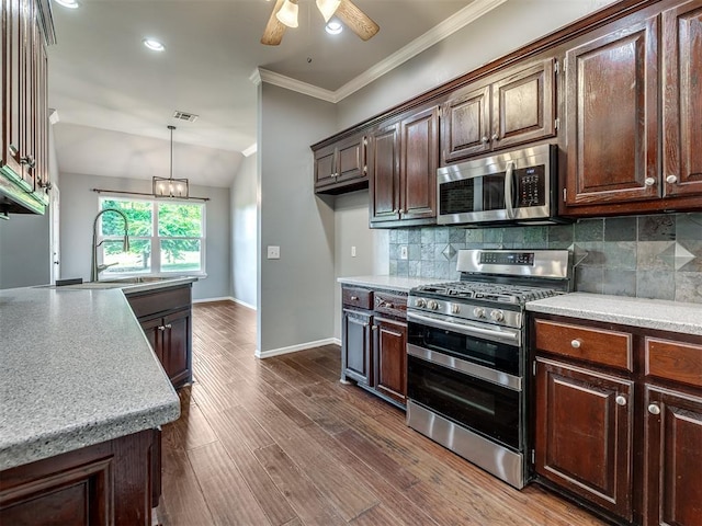 3922 Deer Xing, Edmond, OK 73025 - kitchen with appliances with stainless steel finishes, a ceiling fan, light countertops, tasteful backsplash, and ornamental molding