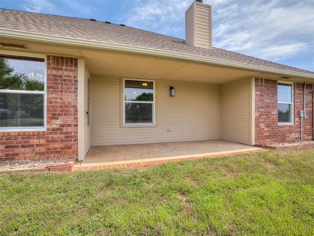 3922 Deer Xing, Edmond, OK 73025 - rear view of property featuring brick siding, a lawn, a patio area, and a chimney