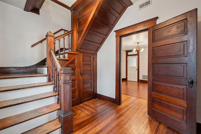 811 S Barker Ave, El Reno, OK 73036 - staircase featuring hardwood / wood-style flooring, lofted ceiling, and a chandelier