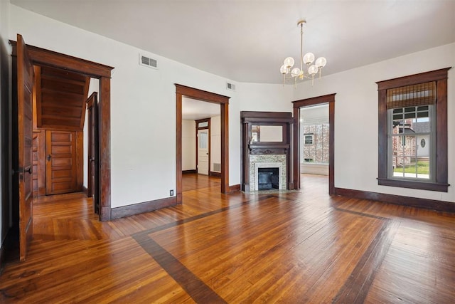 811 S Barker Ave, El Reno, OK 73036 - unfurnished living room featuring a chandelier, wood-type flooring, and a fireplace with flush hearth