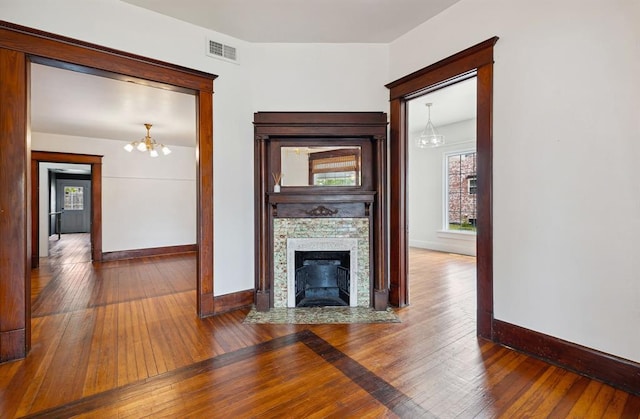 811 S Barker Ave, El Reno, OK 73036 - unfurnished living room with a chandelier, hardwood / wood-style floors, and a fireplace with flush hearth