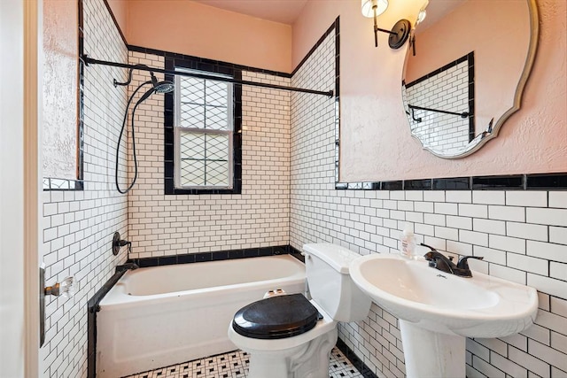 811 S Barker Ave, El Reno, OK 73036 - bathroom featuring tile walls, shower / tub combination, and wainscoting